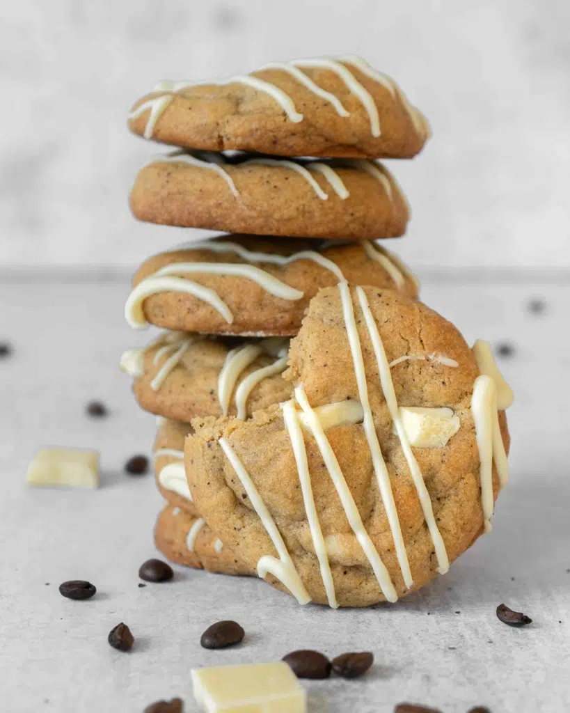 A stack of vegan coffee cookies, drizzled in dairy free white chocolate.