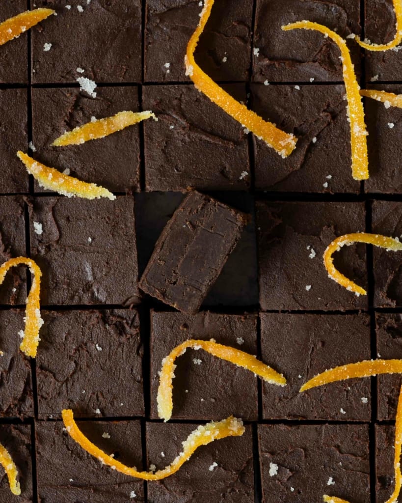 An overhead photo of vegan chocolate orange 5 ingredient fudge cut into squares and decorated with candied orange peel
