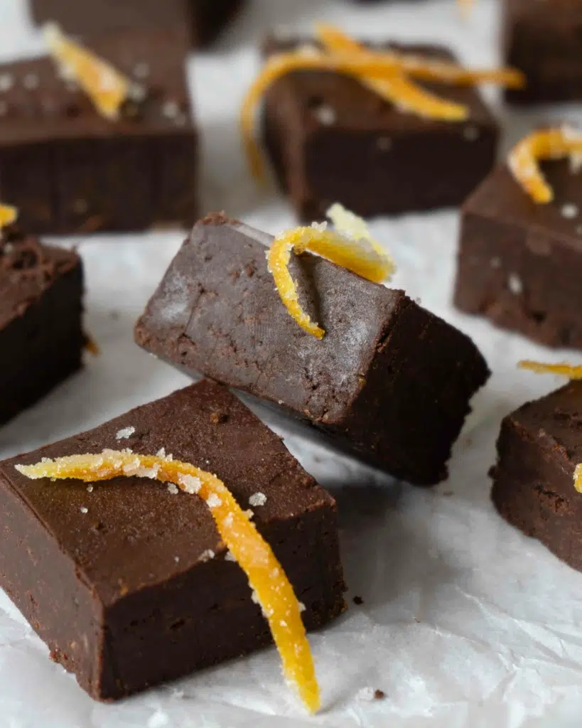 Vegan chocolate orange fudge on a table top, tilted to one side to show the smooth texture