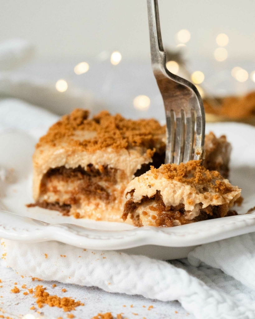 A forkful of Biscoff tiramisu with layers of cinnamon lotus biscuits, creamy mascarpone and crumbled biscuit on top