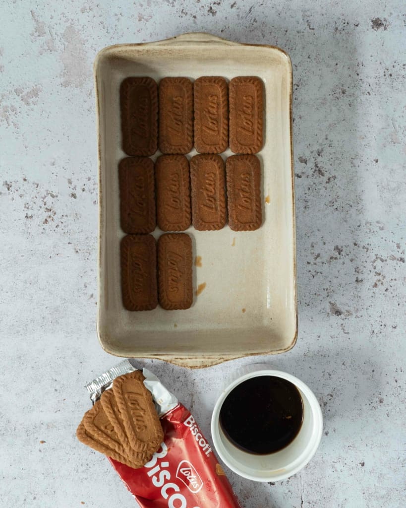 Coffee-dipped lotus biscuits forming a layer in the bottom of a dessert dish