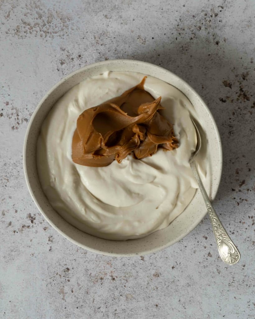 Vegan mascarpone and biscoff spread in a bowl ready to be stirred