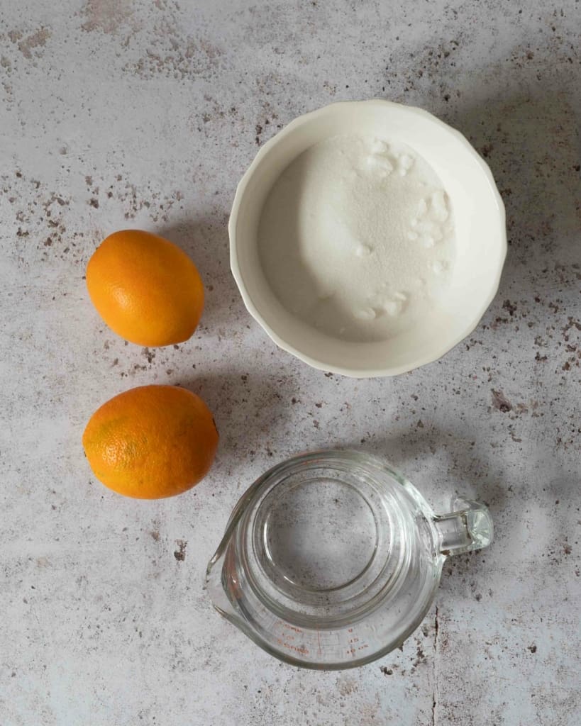 Oranges, sugar and water on a table top