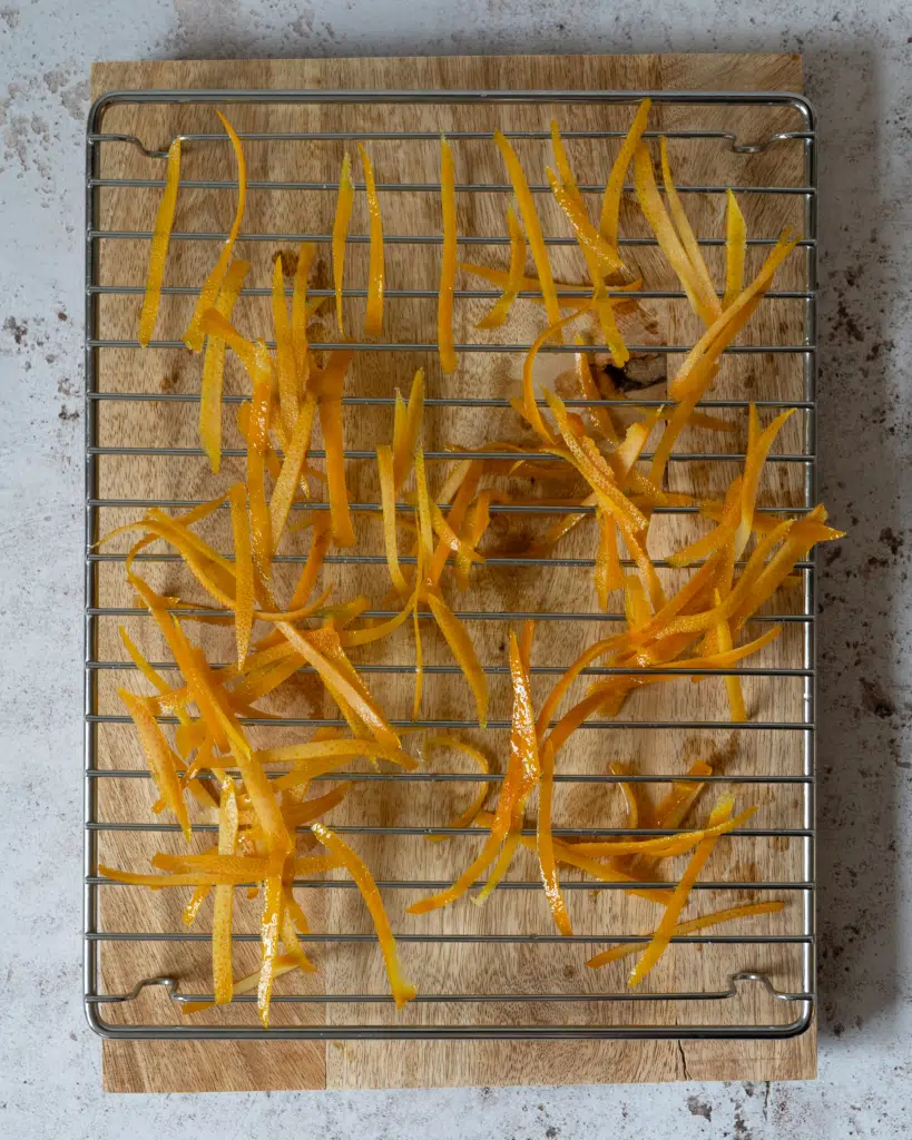 Boiled orange peel spread out on a cooling rack