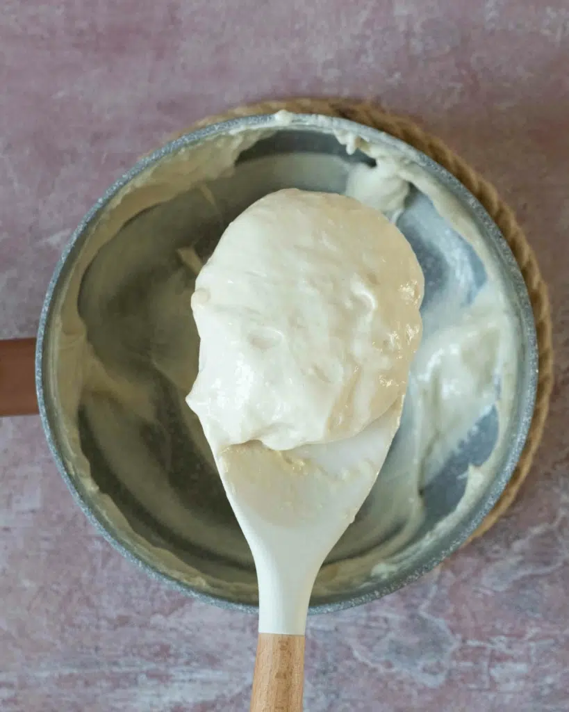 Melted vegan marshmallows on a large spoon over a saucepan
