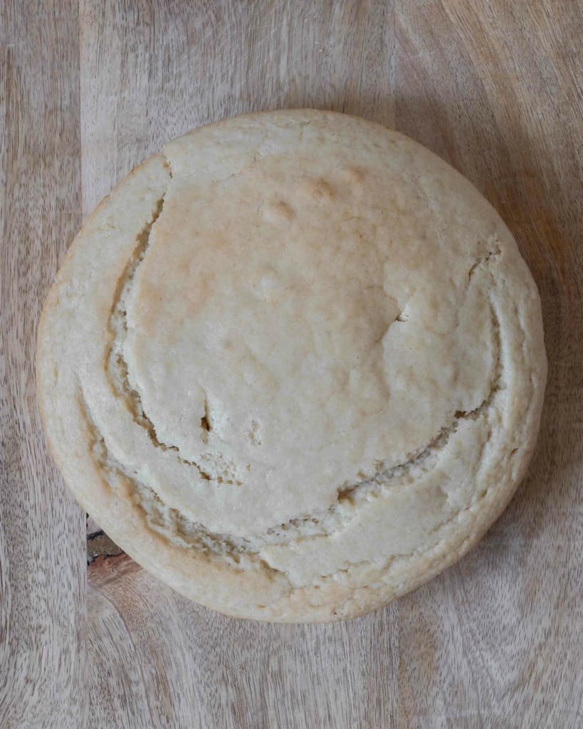 A cooked vegan sponge cake on a wooden chopping board