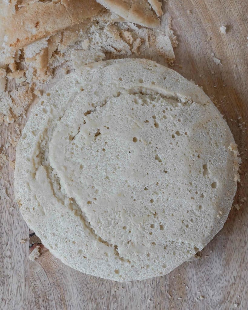 A trimmed vegan sponge cake on a wooden chopping board