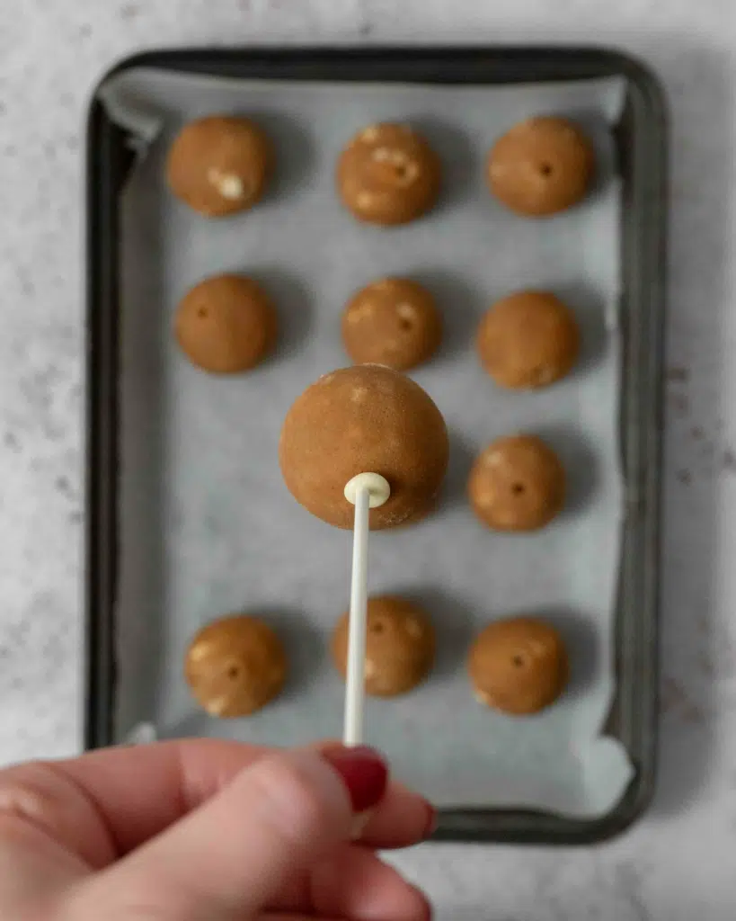 A close up of a Biscoff cake pop, showing how to insert the stick