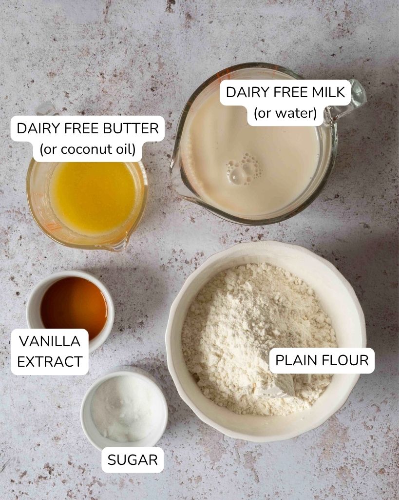 The ingredients needed to make crepes without milk, using water or dairy-free milk, laid out on a table top