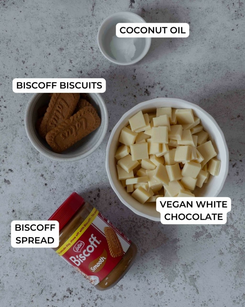 The ingredients to coat white chocolate Biscoff cake pops laid out on a table.