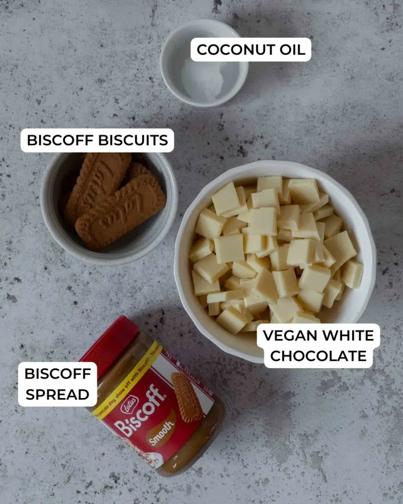 The ingredients to coat white chocolate Biscoff cake pops laid out on a table.