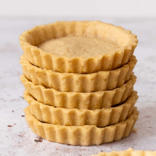 A stack of golden vegan pastry tart shells