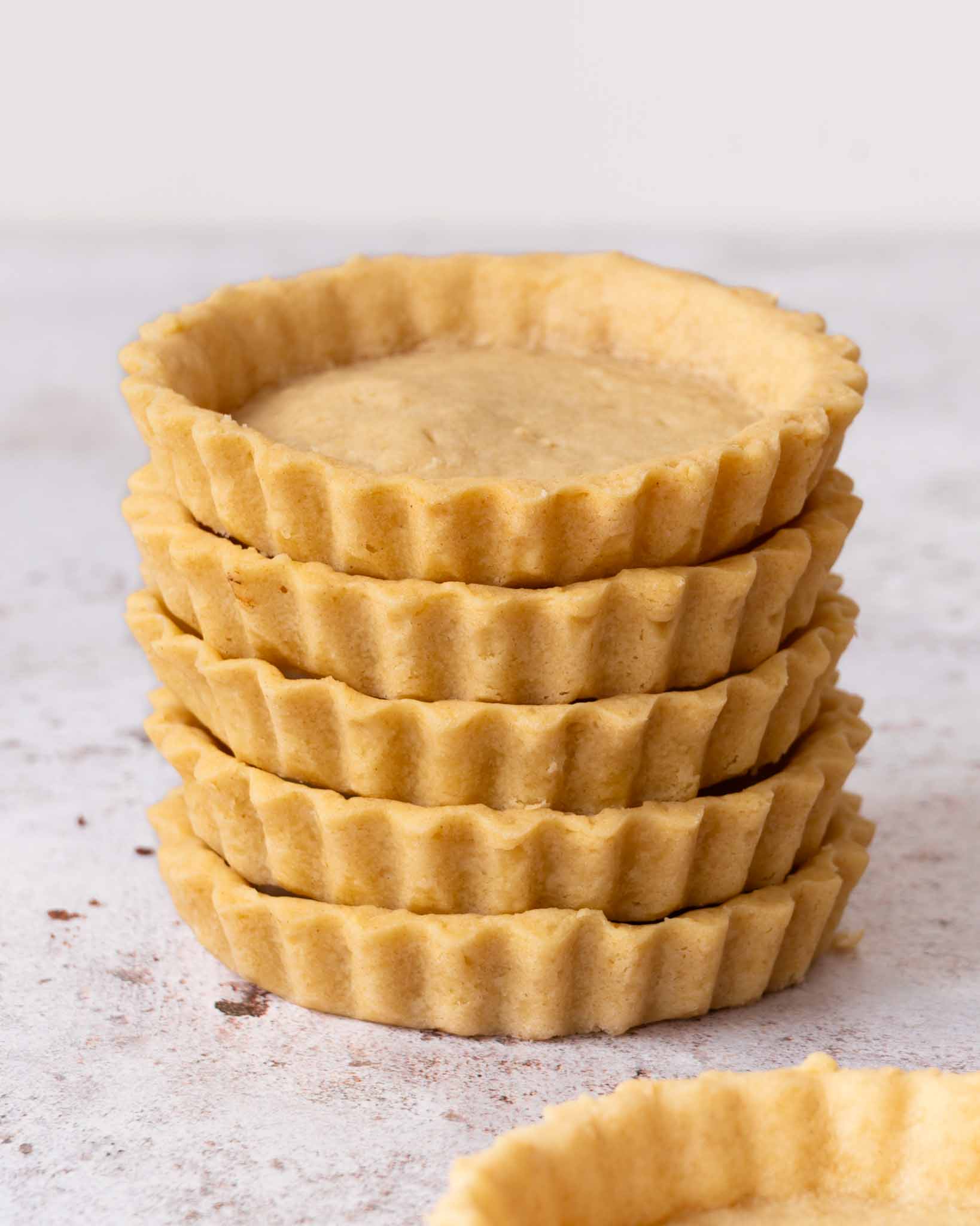 A stack of golden vegan pastry tart shells