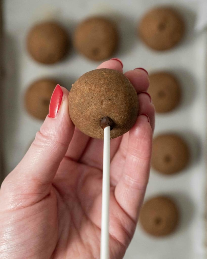 Inserting a cake pop stick into a coffee cake ball