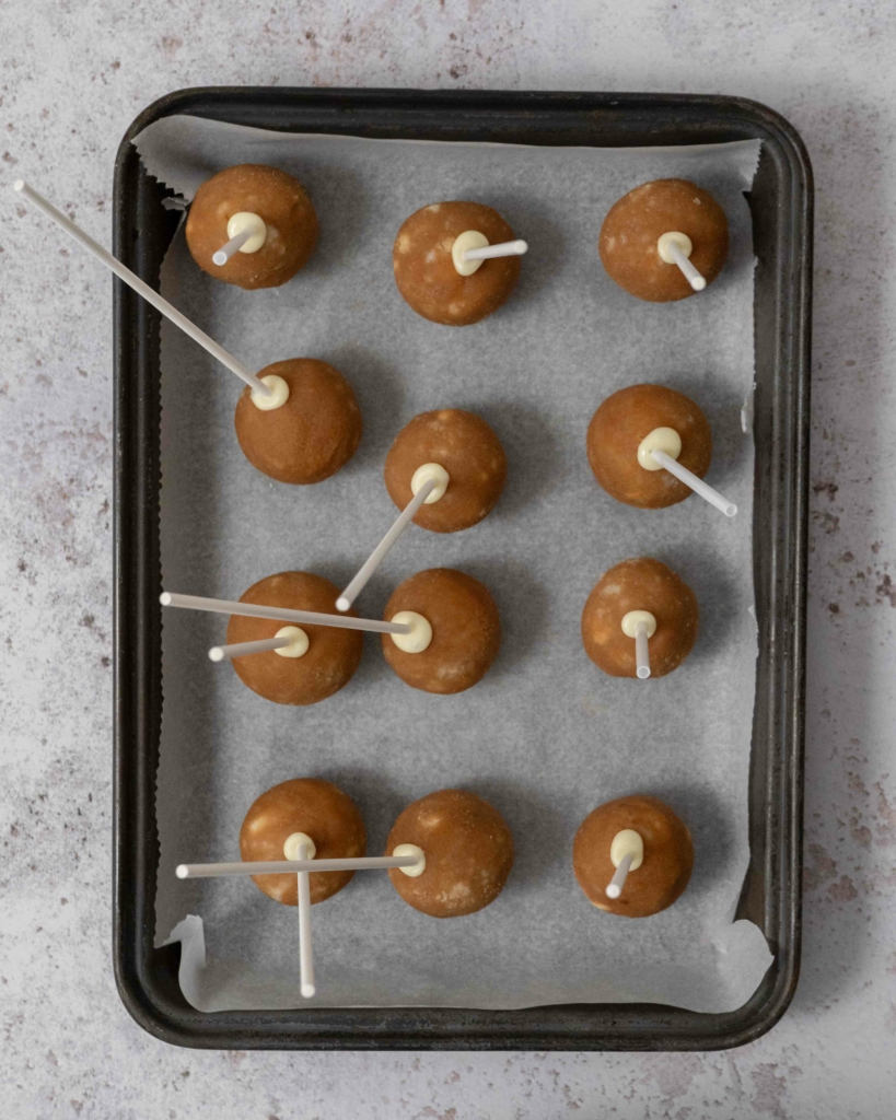 A tray of banana bread cake pops with the sticks inserted