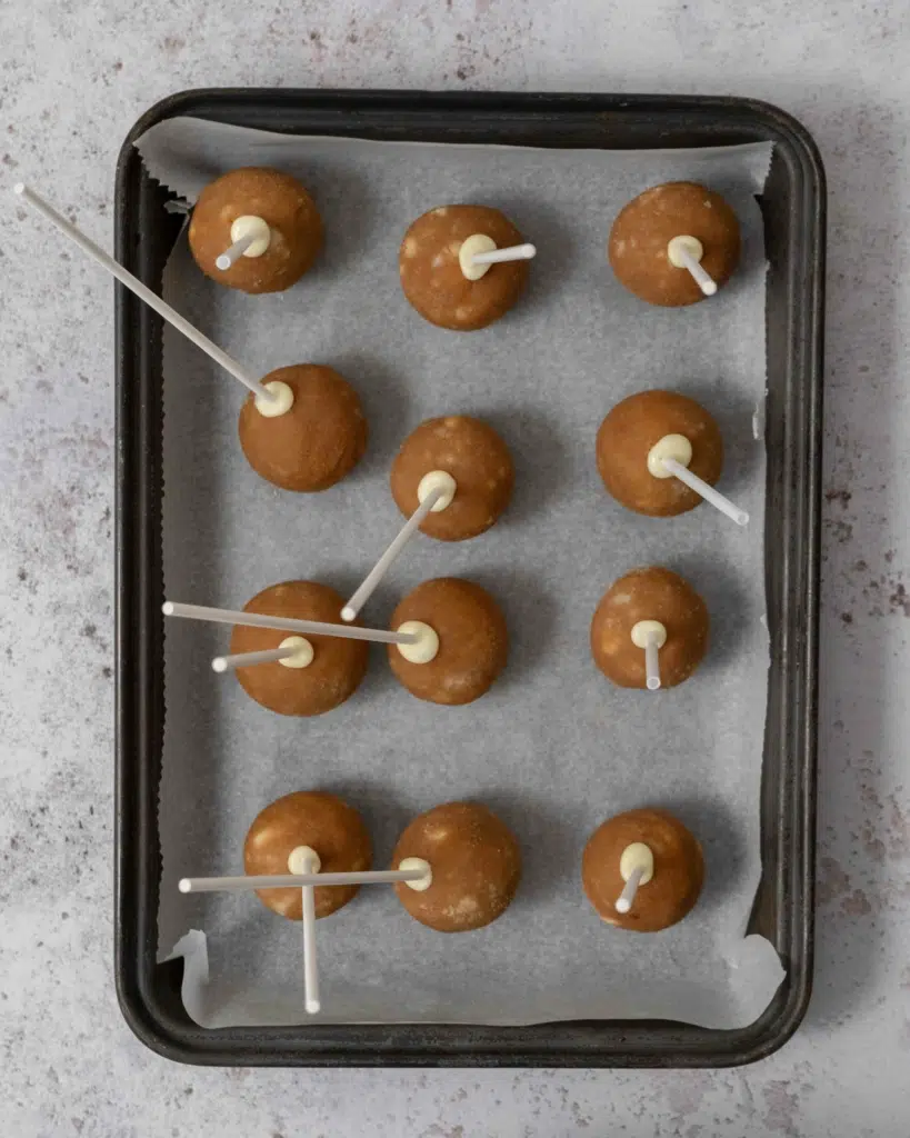 A tray of banana bread cake pops with the sticks inserted