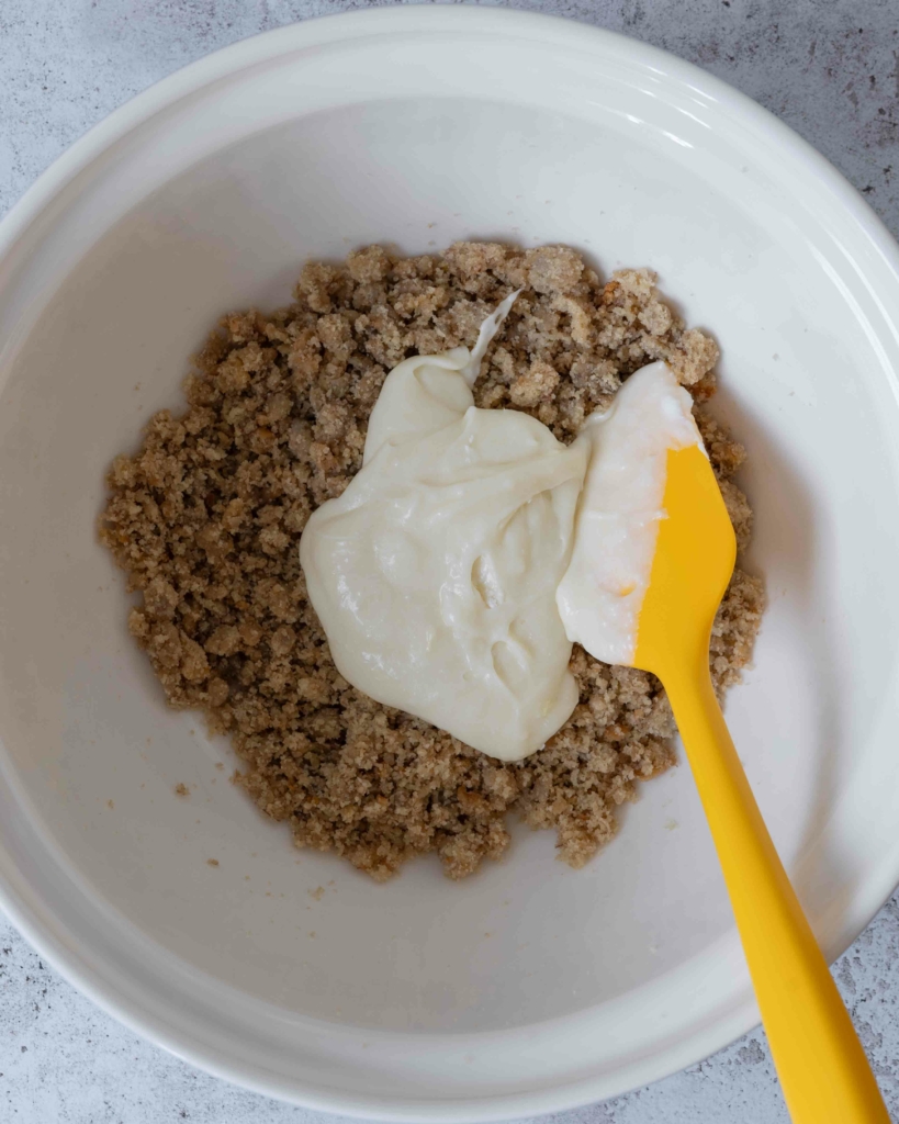Banana bread crumbs and vegan cream cheese in a large mixing bowl ready to make banana bread cake pops