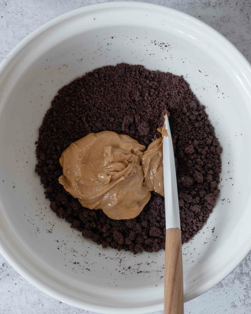 A bowl of cake crumbs and smooth peanut butter