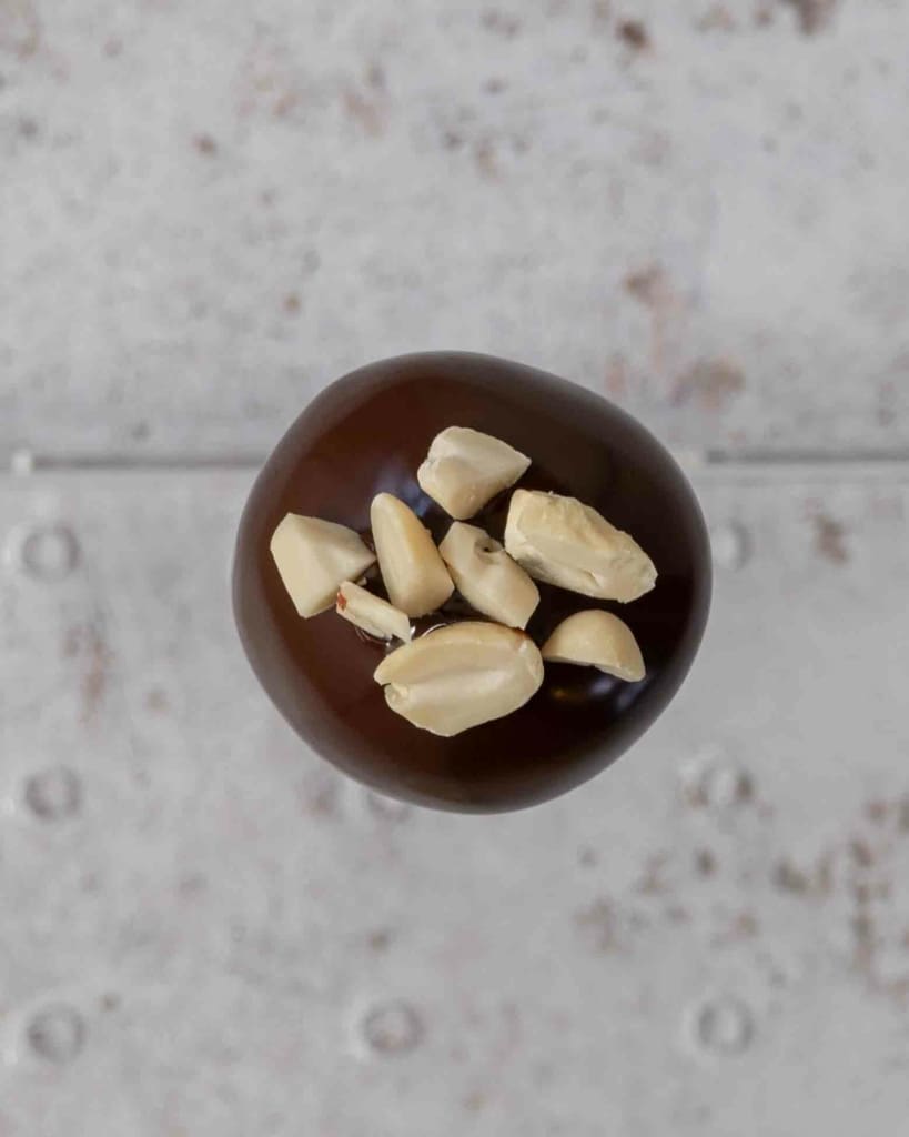The top of a chocolate cake pop, topped with chopped peanuts