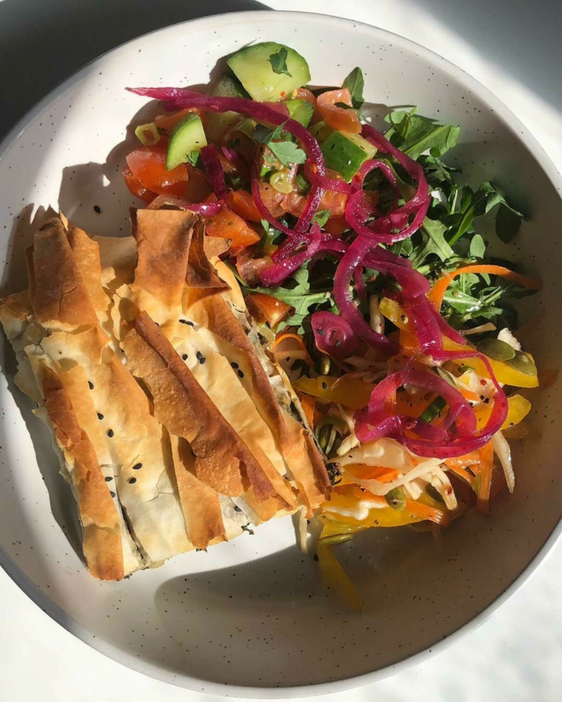 A vegan filo pie with rocket salad and pickled red onions