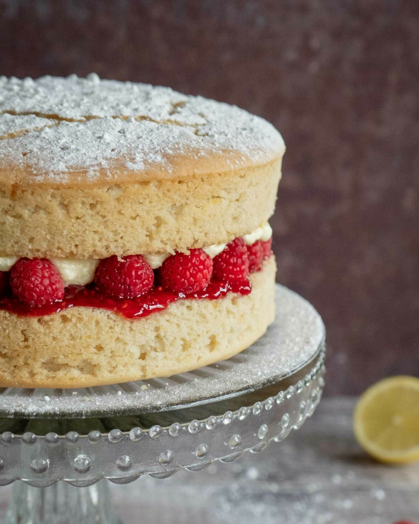 A vegan lemon cake layered with fresh raspberries, raspberry jam and lemon buttercream