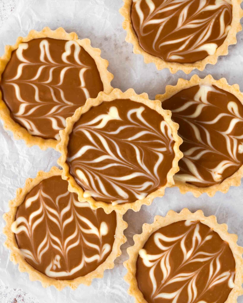 Vegan Biscoff tarts stacked on a white table top