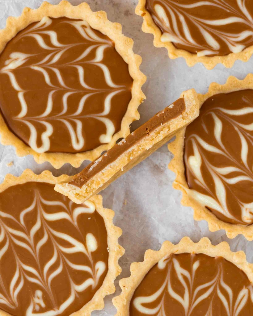 Biscoff tartlets on a table top, one cut in half
