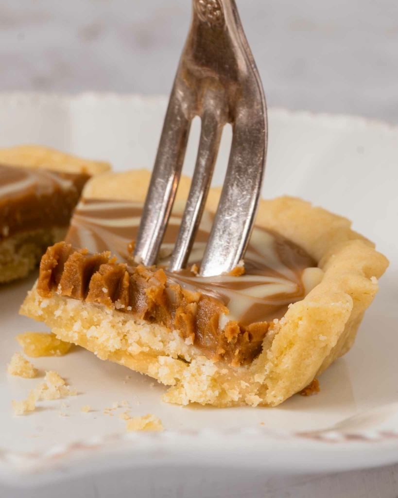 A piece of Biscoff tart speared on a fork, ready to be eaten
