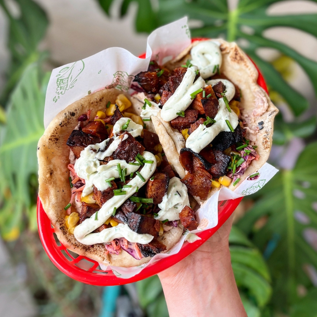 Vegan BBQ 'burnt ends' flatbreads in a red dish from How On Earth Vegan Deli - voted one of the best vegan restaurants in Devon!