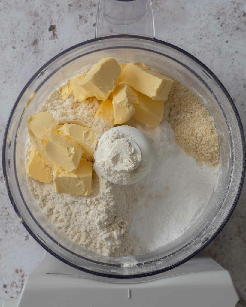 Vegan butter, flour and sugar in a food processor ready to be turned into pastry