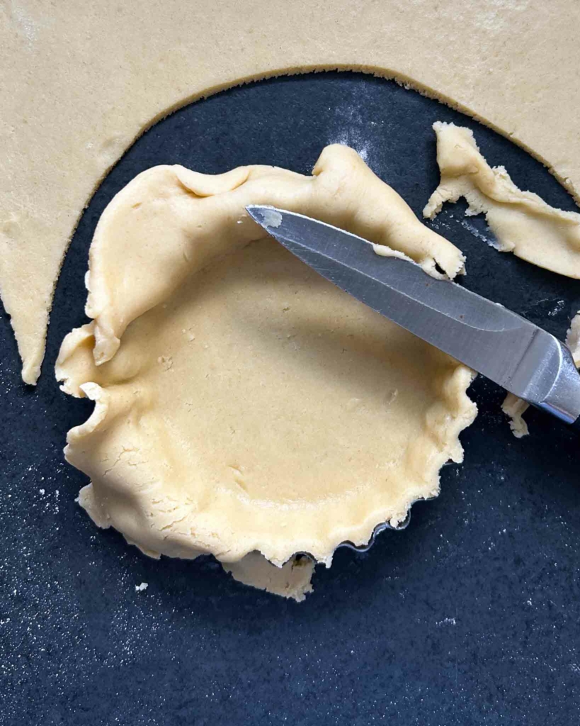 Vegan pastry being fitted to a tart tin