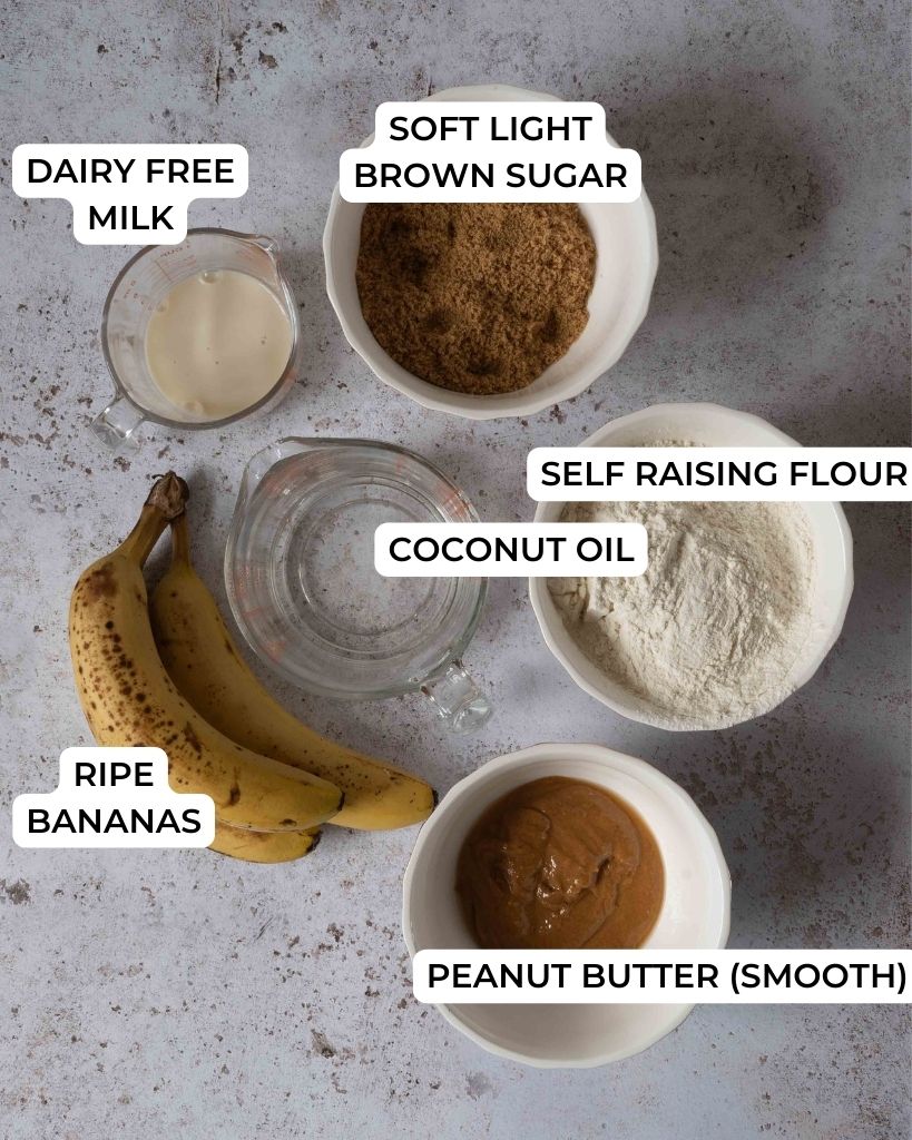 The ingredients needed to make vegan peanut butter banana bread set out on a table top