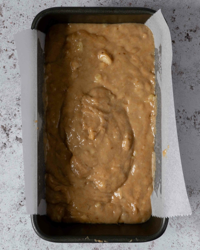 Banana bread batter in a lined loaf pan