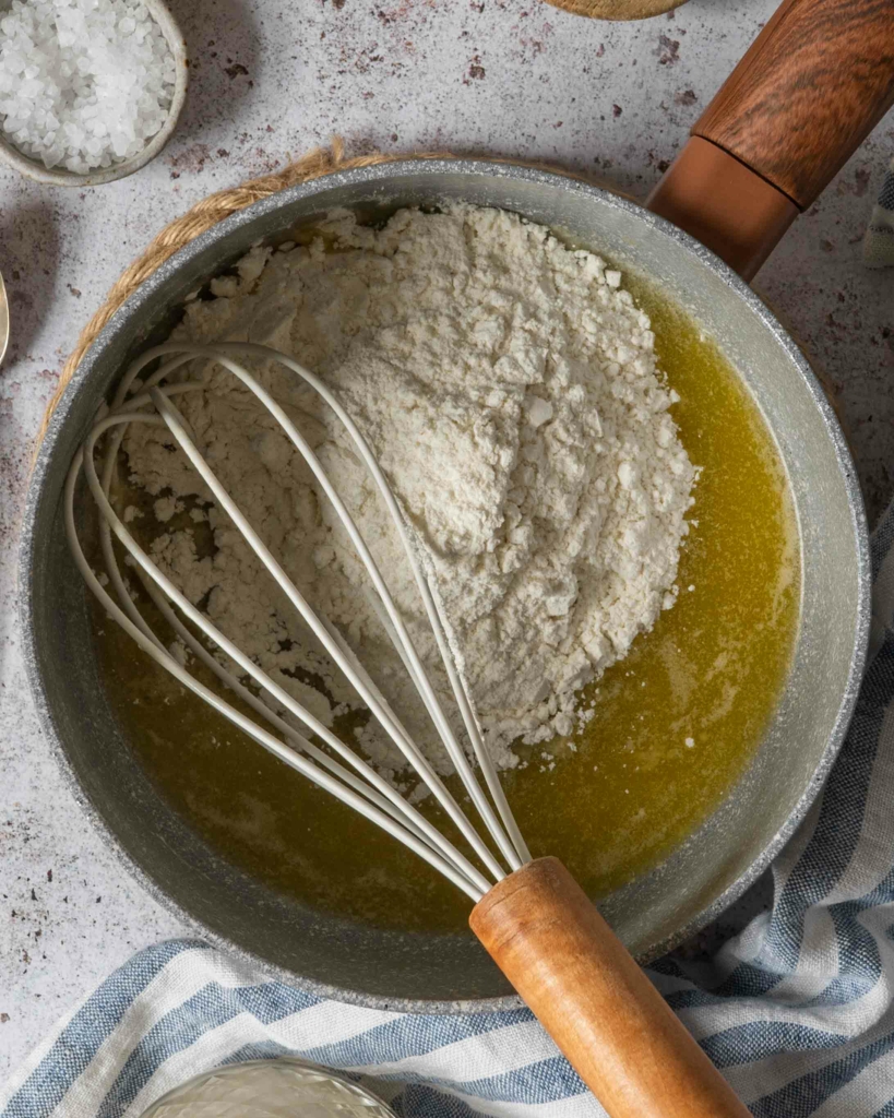 Melted margarine and flour in a saucepan ready to make vegan bechamel sauce with oat milk