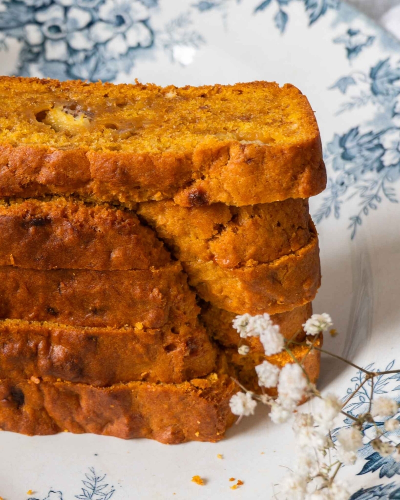 A close up stack of vegan banana pumpkin bread on a pretty floral plate