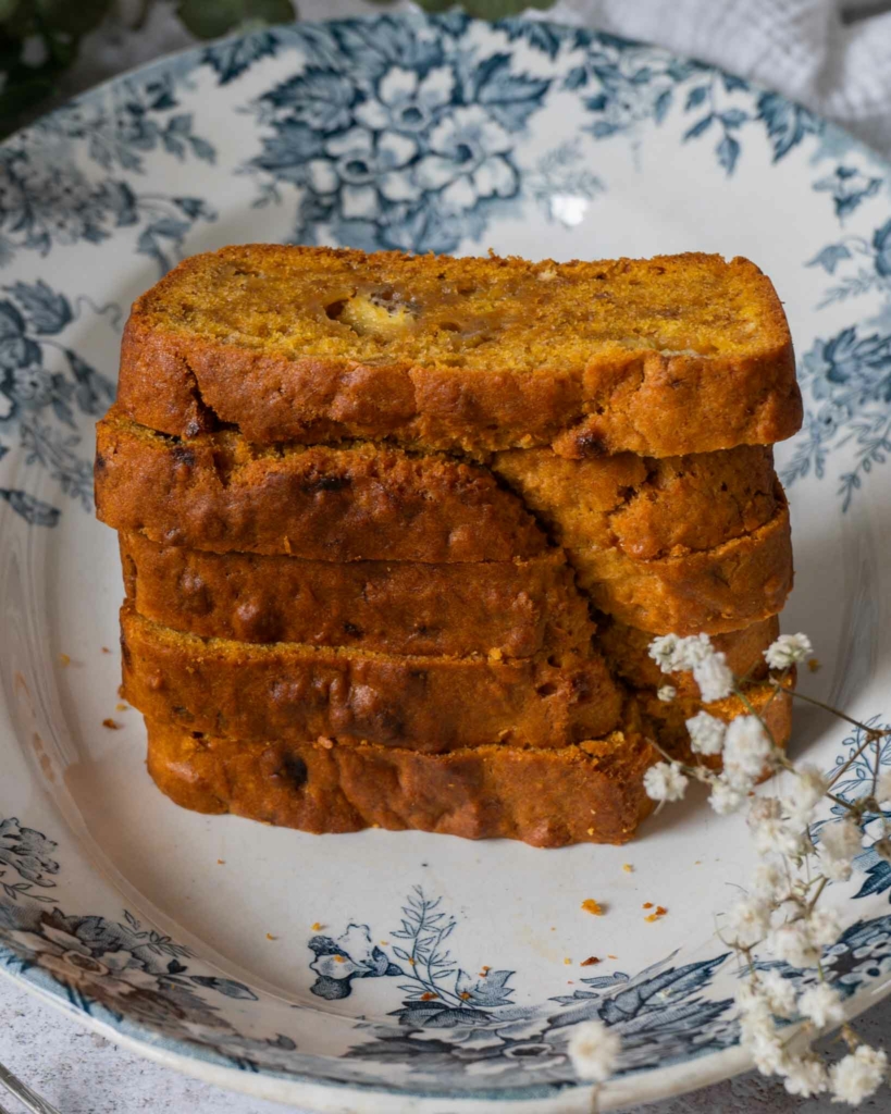 A stack of pumpkin banana bread slices on a pretty blue floral plate.
