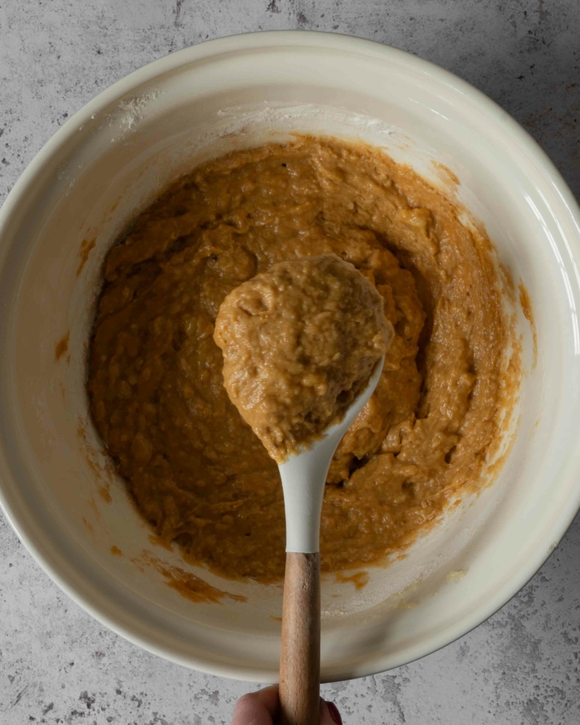 A mixing spoon filled with banana bread batter.