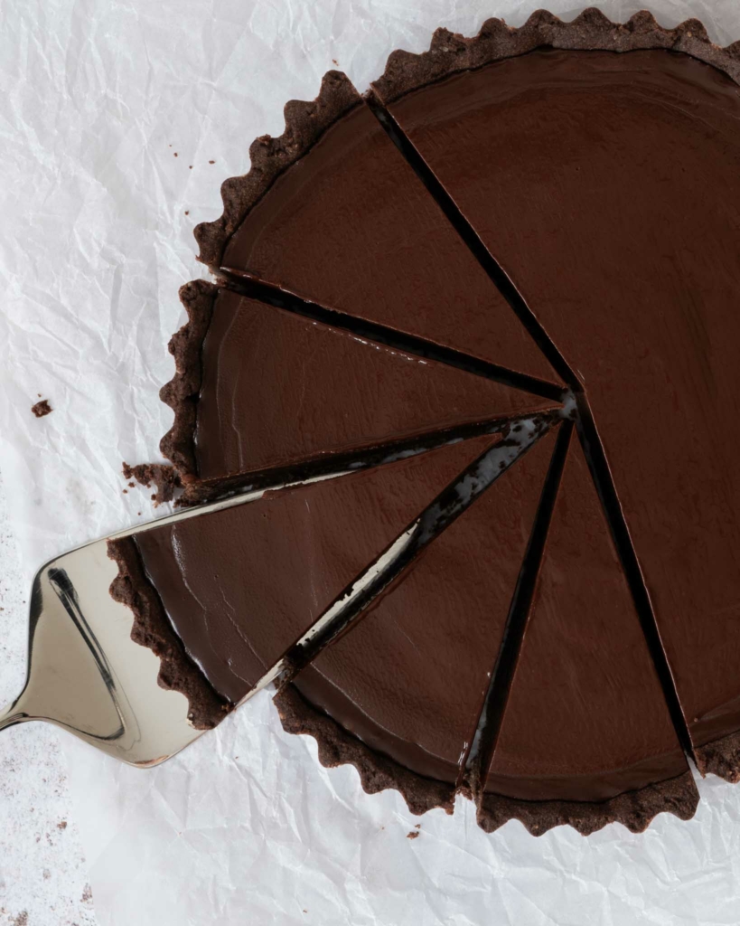 An overhead photo of a French Chocolate Tart with slices cut out