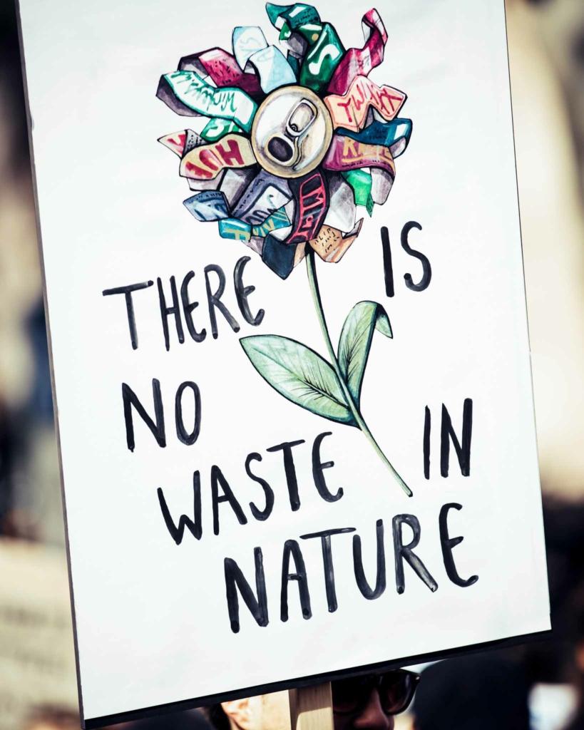 Sign that says 'there is no waste in nature' with a drawing of a flower made of waste