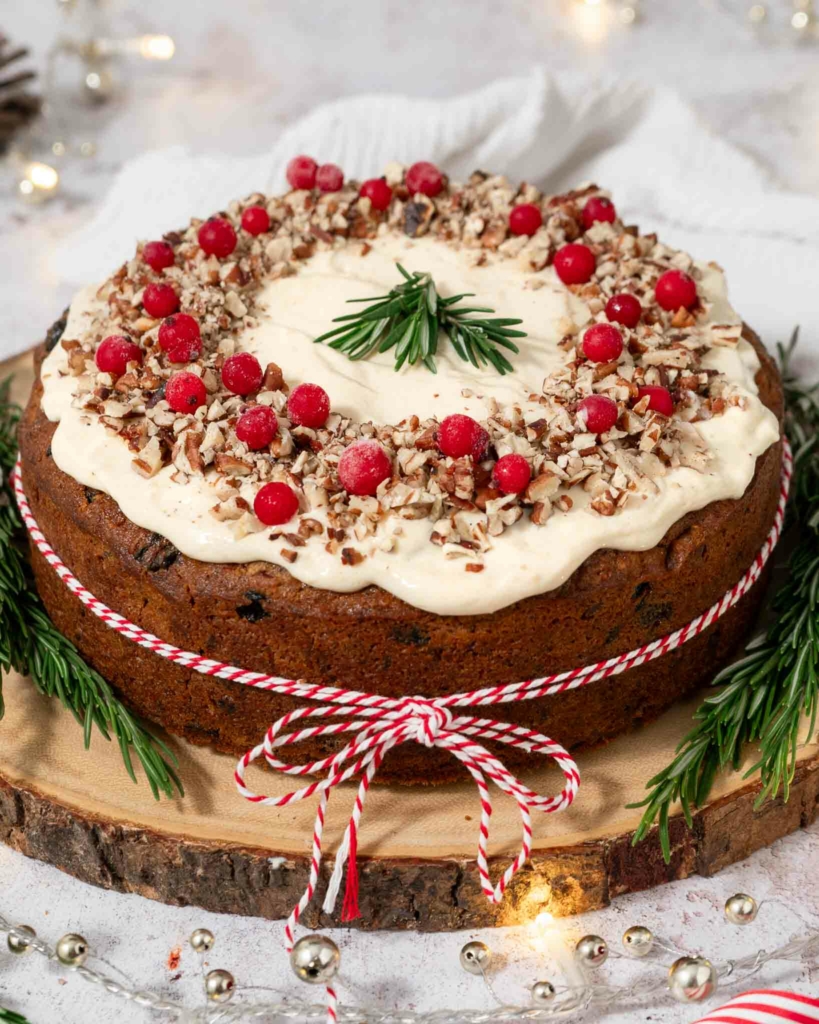 A festive carrot cake sat on a wooden board