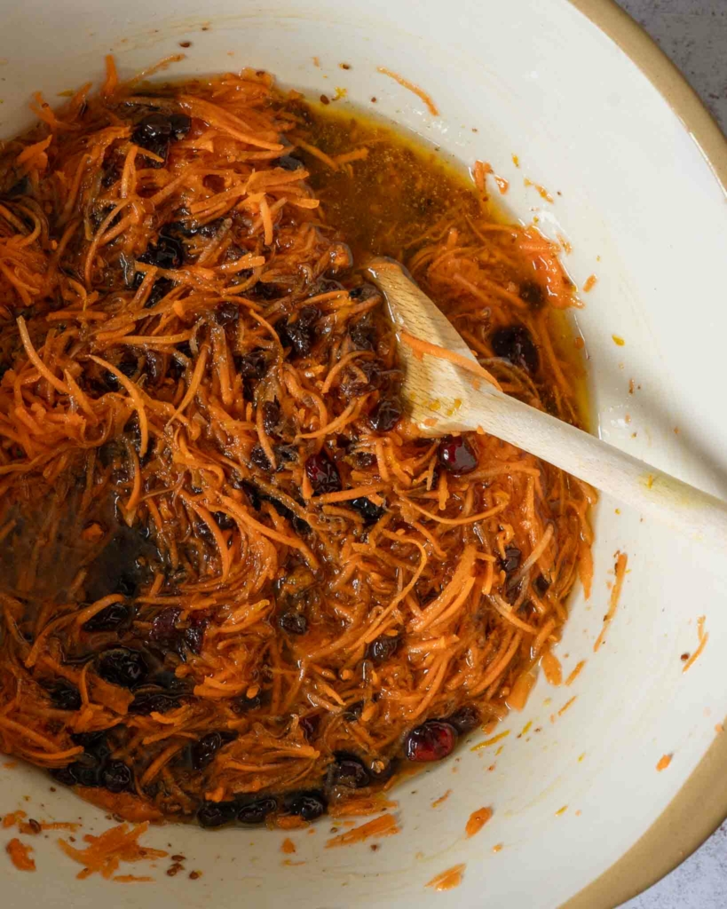 Grated carrot in a bowl with some cake mixture