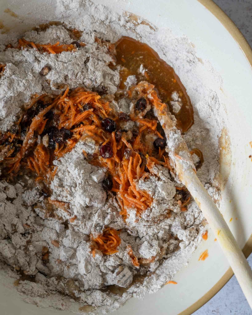 Flour being mixed into a carrot cake batter