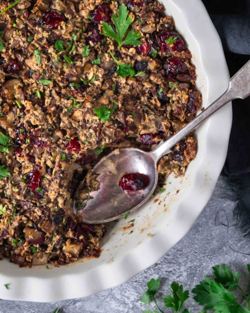A dish of freshly cooked vegan chestnut stuffing, with a spoonful missing