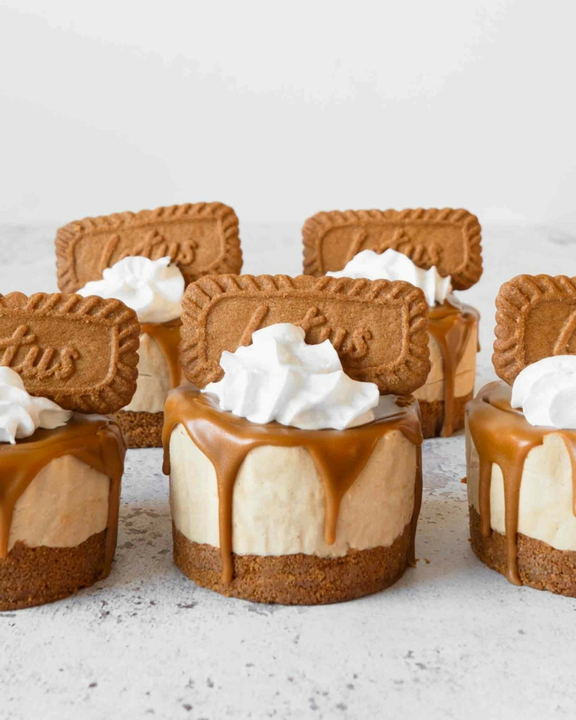 No bake Biscoff mini cheesecakes with whipped cream and a speculoos biscuit on top