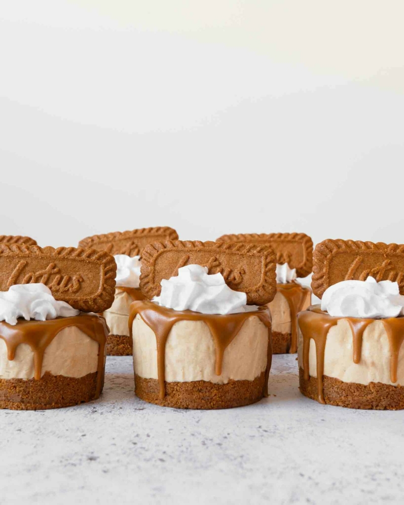 No bake Biscoff mini cheesecakes with whipped cream and a speculoos biscuit on top