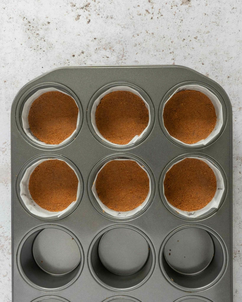 Biscoff biscuit crumbs pressed into a dessert pan