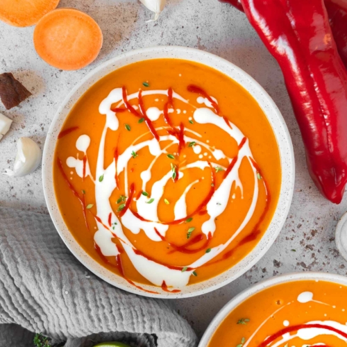 Two bowls of sweet potato chilli coconut soup on a tabletop