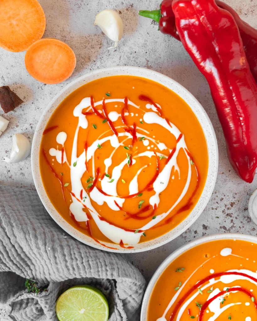 Two bowls of sweet potato chilli coconut soup on a tabletop