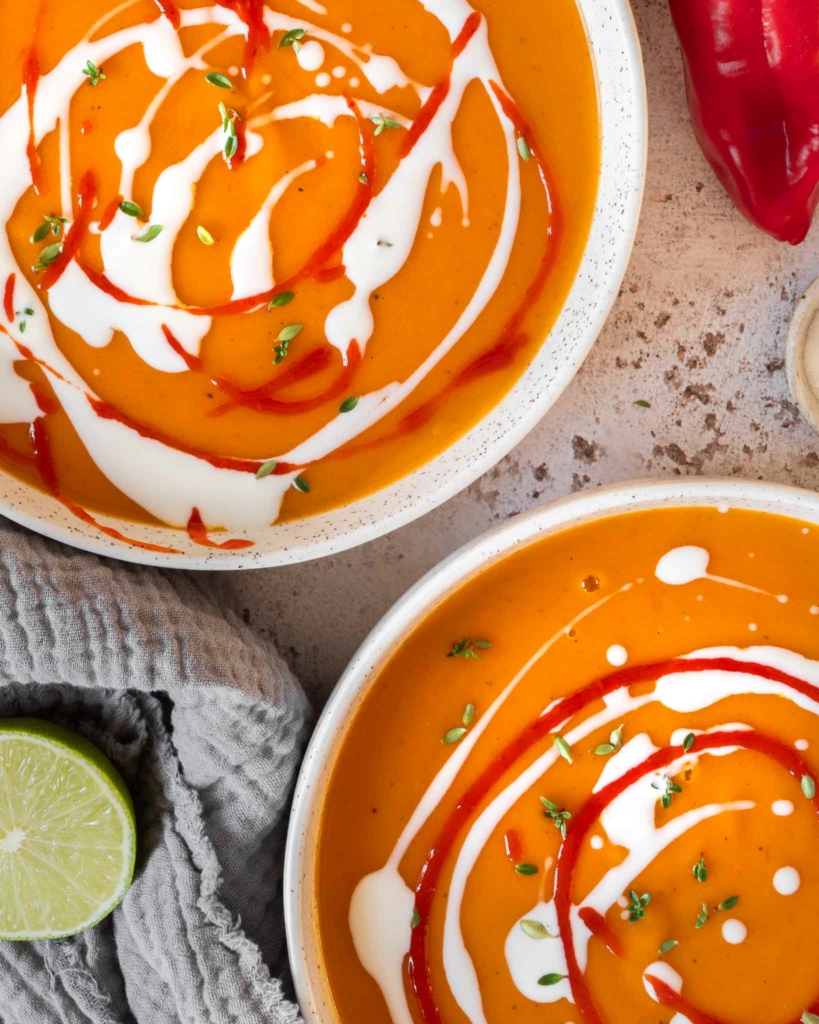 Two bowls of sweet potato chilli coconut soup on a tabletop