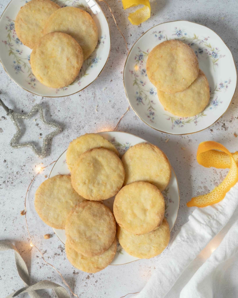 Vegan lemon shortbread cookies stacked on pretty vintage plates
